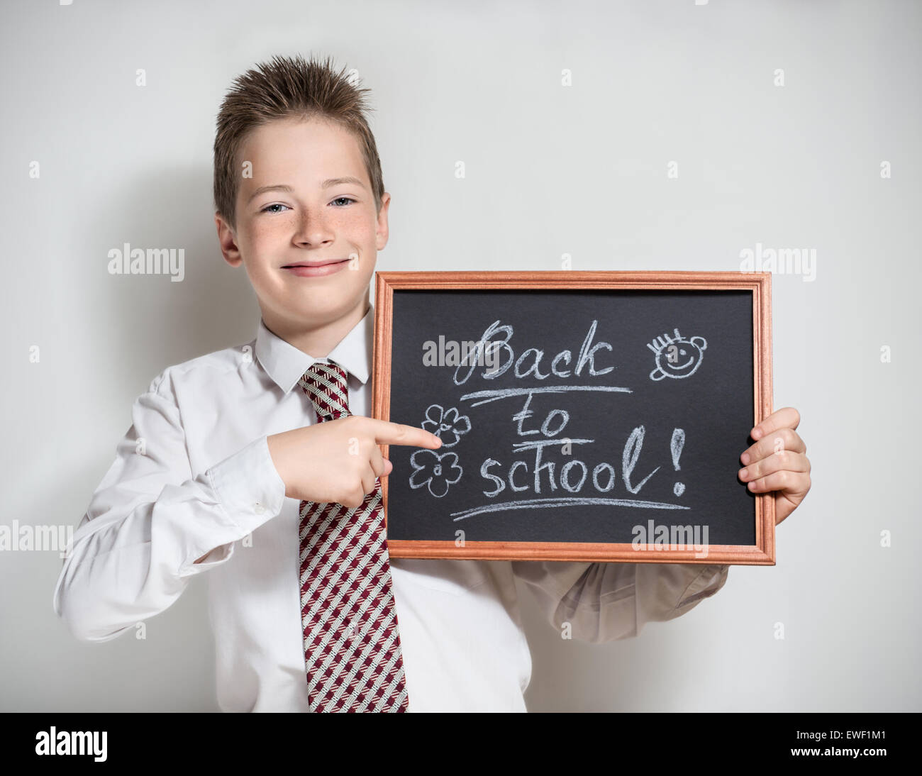 Smiling schoolboy with empty black chalkboard Stock Photo