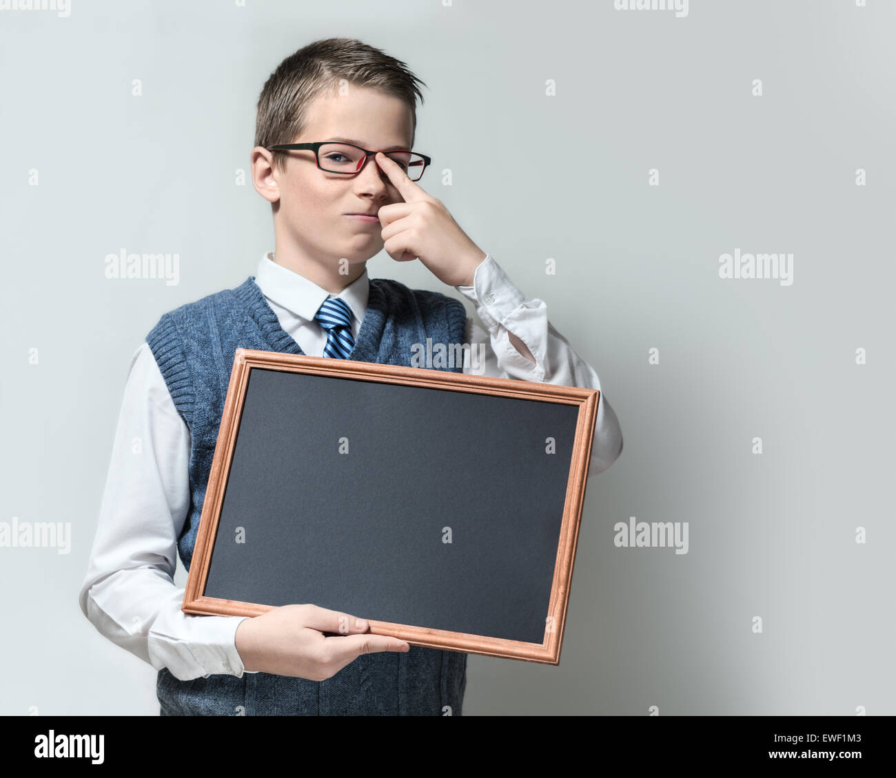 Smart schoolboy in glasses with empty chalkboard Stock Photo