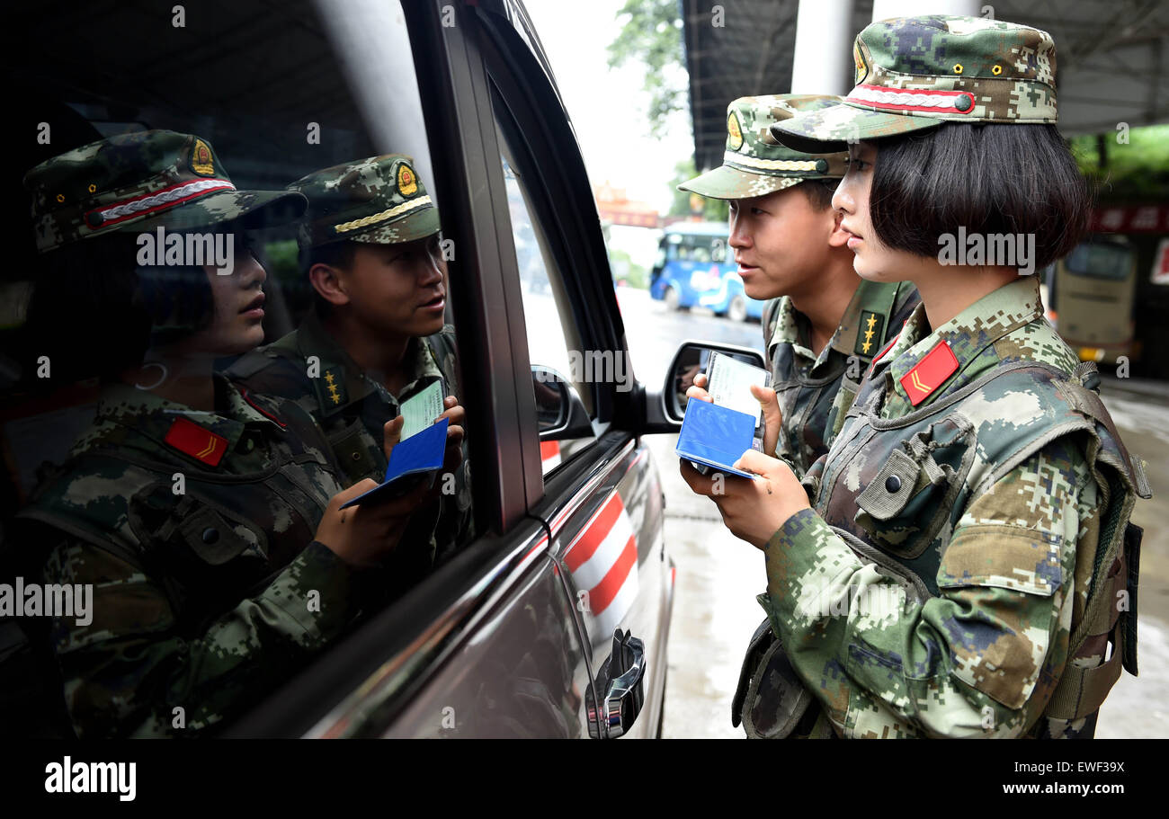 (150625) -- DEHONG, June 25, 2015 (Xinhua) -- Zhang Liu (R) and her comrade check a car at the border checkpoint of Mukang in Dehong Dai-Jingpo Autonomous Prefecture, southwest China's Yunnan Province, June 24, 2015. Born in 1995, Zhang Liu became an anti-drug soldier in border checkpoint of Mukang in 2013. Grown up in an affluent family in central China's Hunan Province, Zhang said that being a soldier had always been her dream, which drove her to join the army after graduating from high school. Being a front line anti-drug force, the border checkpoint of Mukang has captured about 100 kilogr Stock Photo