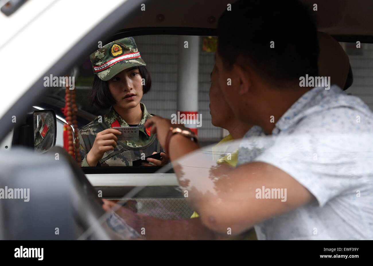 (150625) -- DEHONG, June 25, 2015 (Xinhua) -- Zhang Liu checks the information of a driver at the border checkpoint of Mukang in Dehong Dai-Jingpo Autonomous Prefecture, southwest China's Yunnan Province, June 24, 2015. Born in 1995, Zhang Liu became an anti-drug soldier in border checkpoint of Mukang in 2013.  Grown up in an affluent family in central China's Hunan Province, Zhang said that being a soldier had always been her dream, which drove her to join the army after graduating from high school. Being a front line anti-drug force, the border checkpoint of Mukang has captured about 100 kil Stock Photo