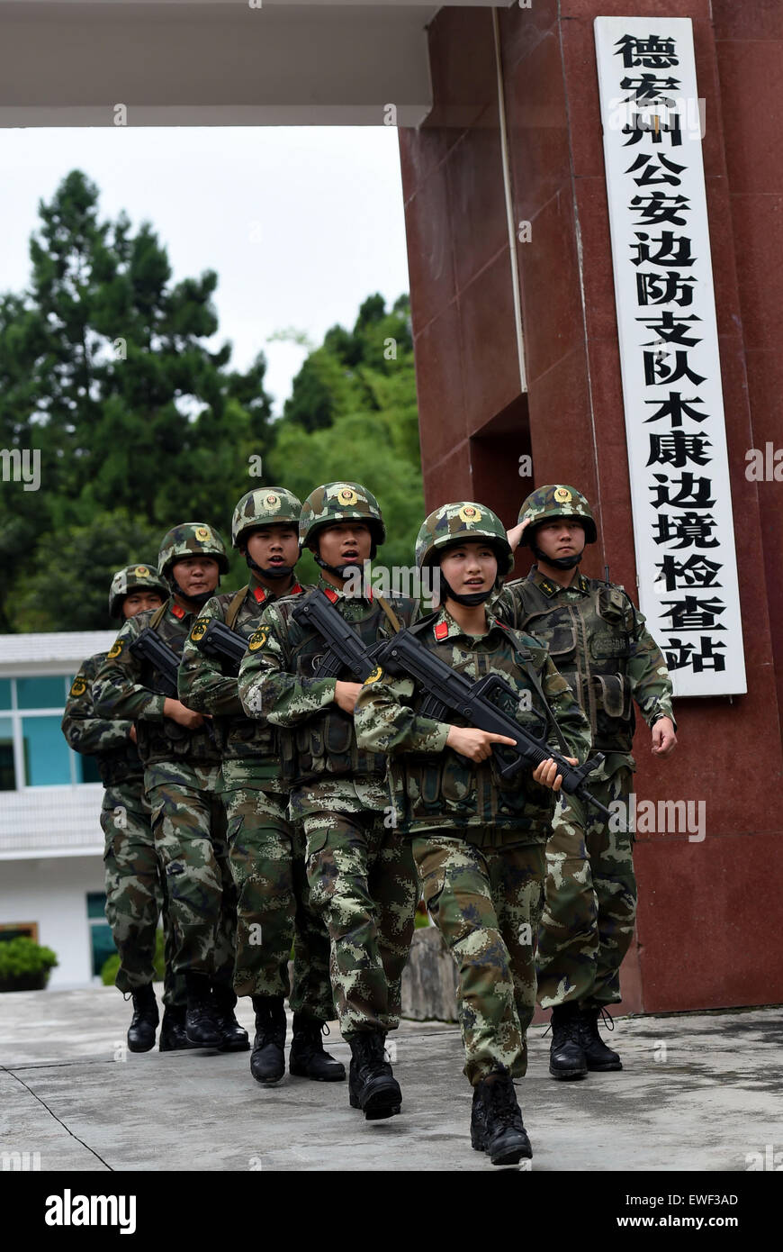 (150625) -- DEHONG, June 25, 2015 (Xinhua) -- Zhang Liu (front) and her comrades walk in line at the gate of the border checkpoint of Mukang in Dehong Dai-Jingpo Autonomous Prefecture, southwest China's Yunnan Province, June 24, 2015. Born in 1995, Zhang Liu became an anti-drug soldier in border checkpoint of Mukang in 2013.  Grown up in an affluent family in central China's Hunan Province, Zhang said that being a soldier had always been her dream, which drove her to join the army after graduating from high school. Being a front line anti-drug force, the border checkpoint of Mukang has capture Stock Photo