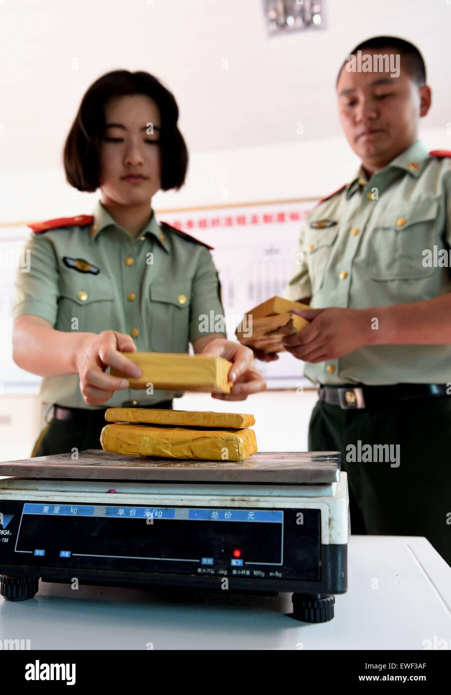 (150625) -- DEHONG, June 25, 2015 (Xinhua) -- Zhang Liu (L) and her comrade prepare to weigh drugs they captured at border checkpoint of Mukang in Dehong Dai-Jingpo Autonomous Prefecture, southwest China's Yunnan Province, June 24, 2015. Born in 1995, Zhang Liu became an anti-drug soldier in border checkpoint of Mukang in 2013. Grown up in an affluent family in central China's Hunan Province, Zhang said that being a soldier had always been her dream, which drove her to join the army after graduating from high school. Being a front line anti-drug force, the border checkpoint of Mukang has capt Stock Photo