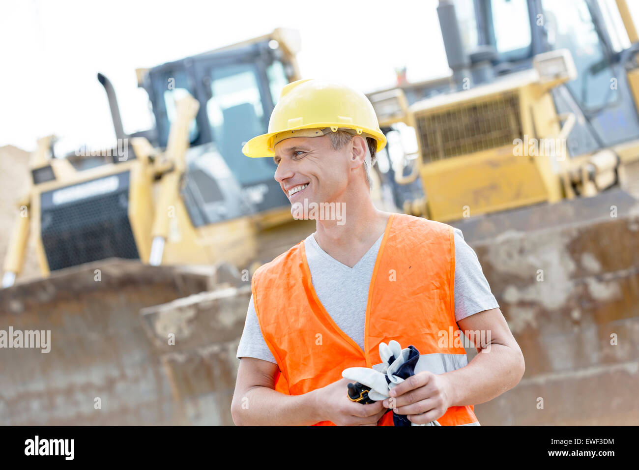 Happy supervisor looking away at construction site Stock Photo
