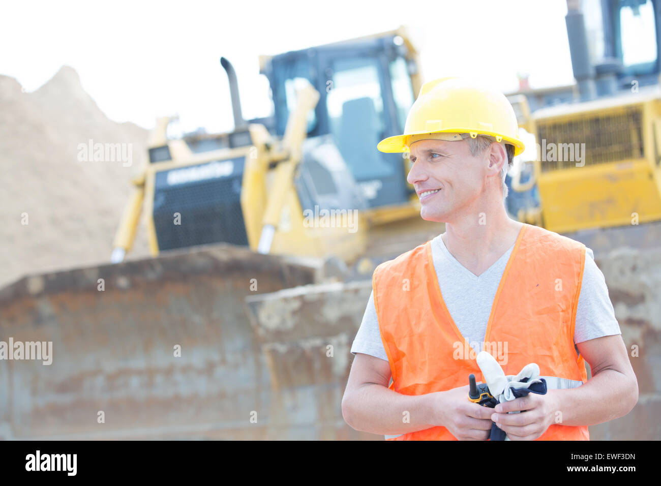 Smiling supervisor looking away at construction site Stock Photo