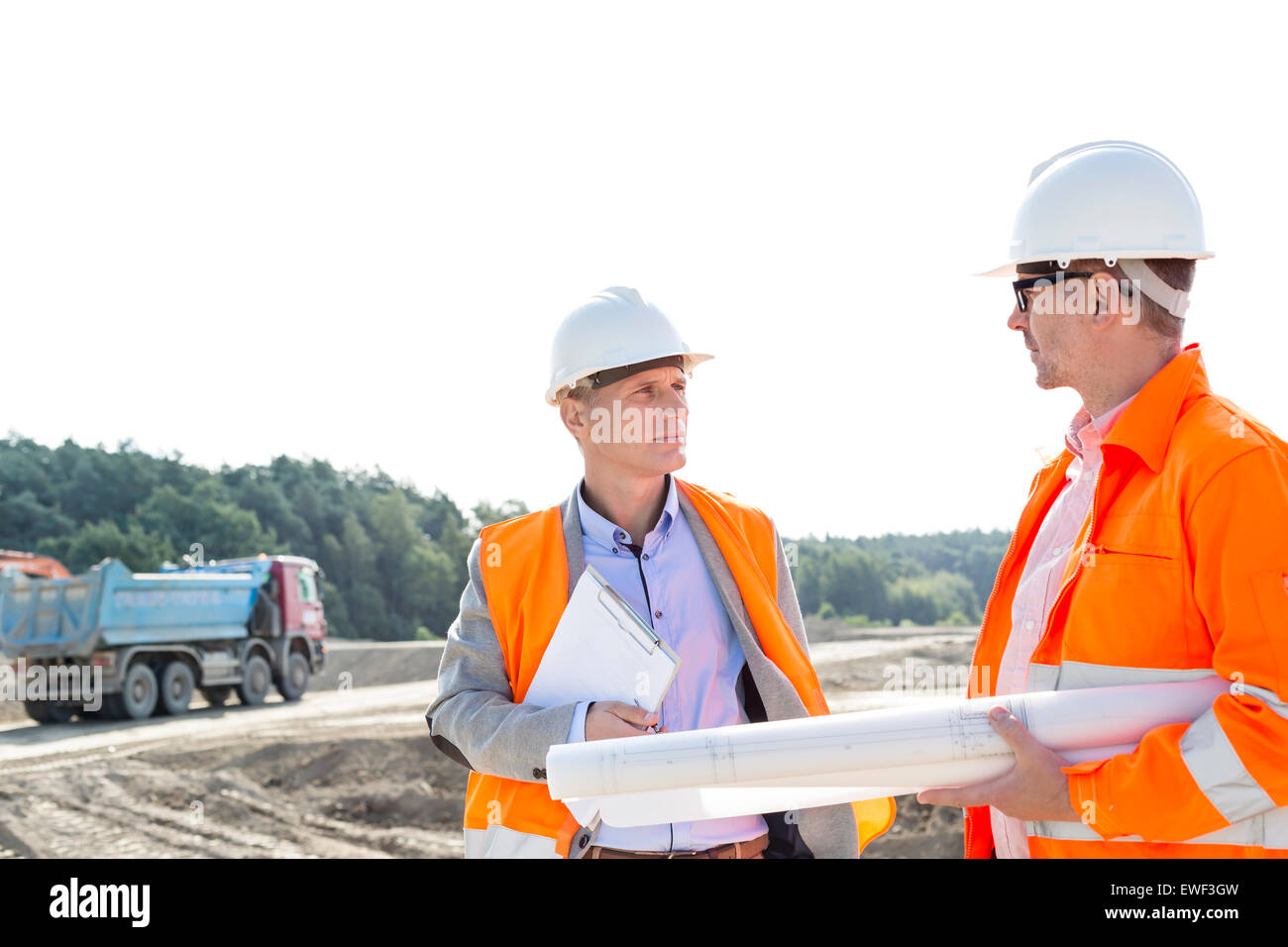 Engineers discussing at construction site against clear sky Stock Photo