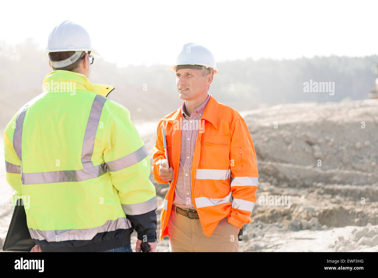 Supervisors discussing at construction site on sunny day Stock Photo
