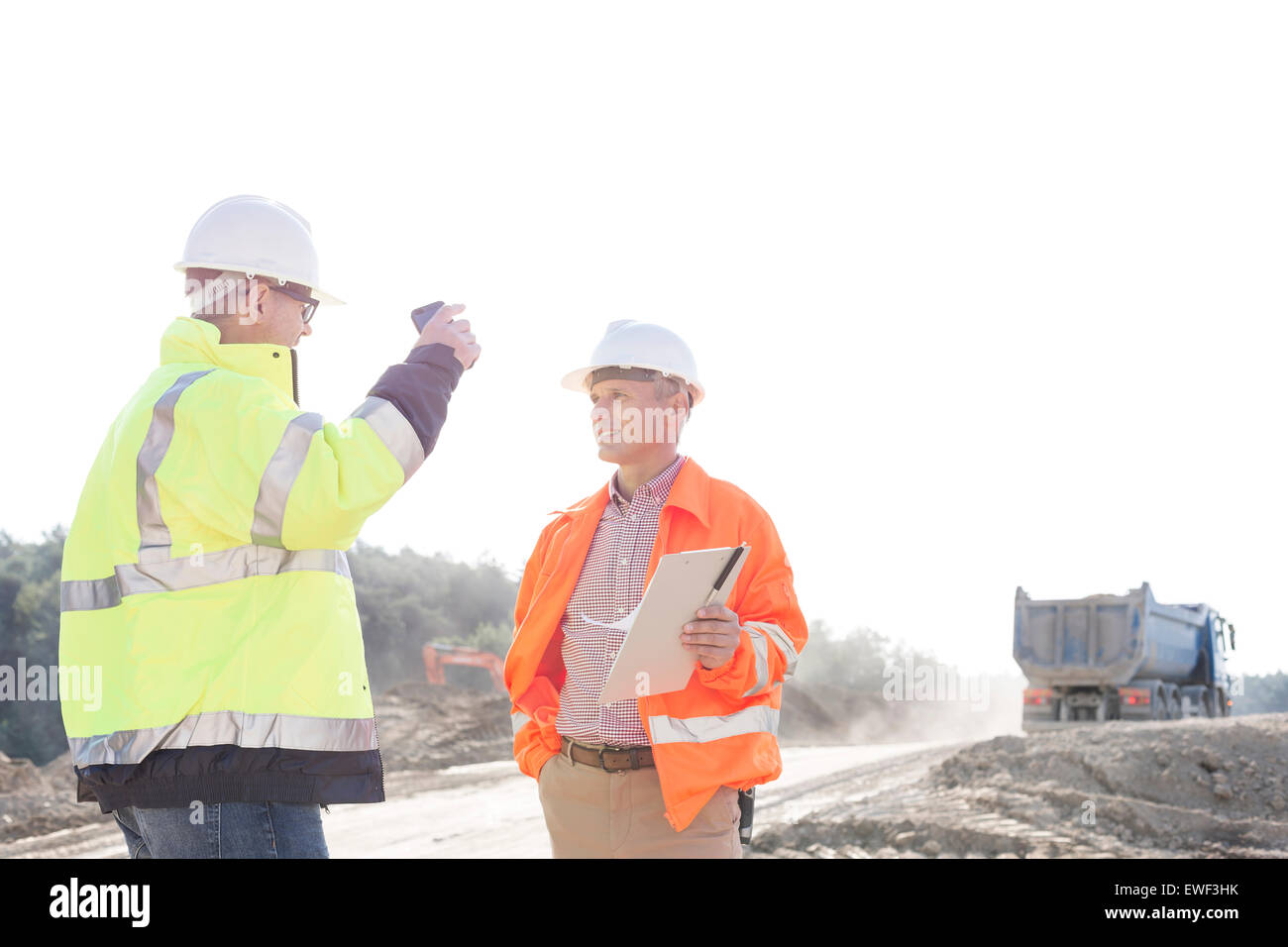 Supervisors discussing at construction site against clear sky Stock Photo