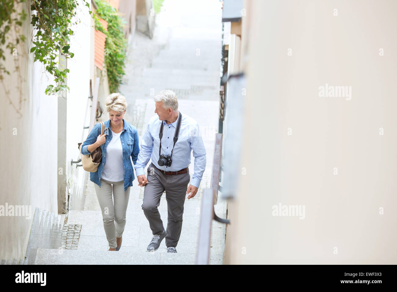 High angle view of middle-aged couple holding hands while climbing steps outdoors Stock Photo