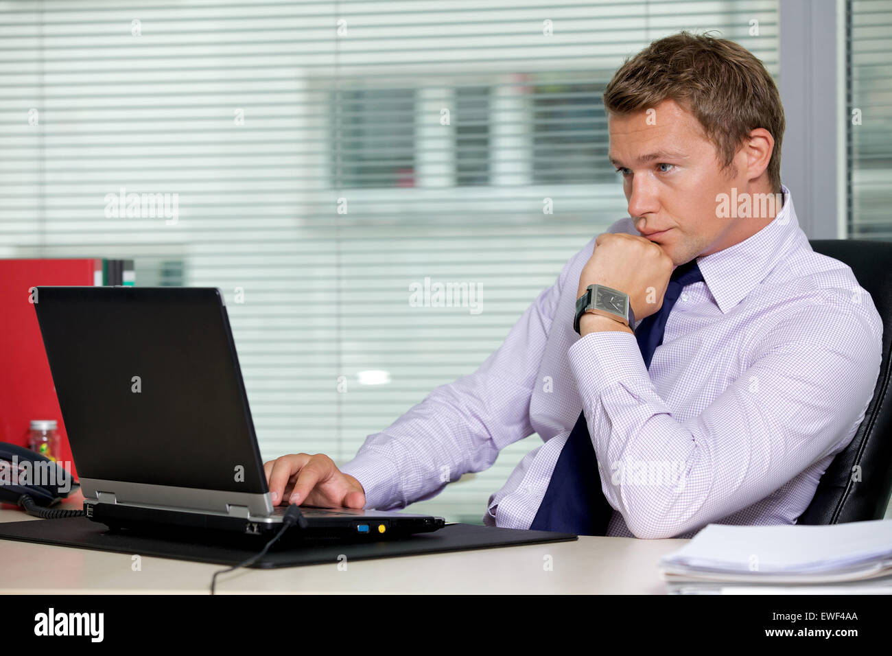 Businessman sitting with laptop at office Stock Photo - Alamy