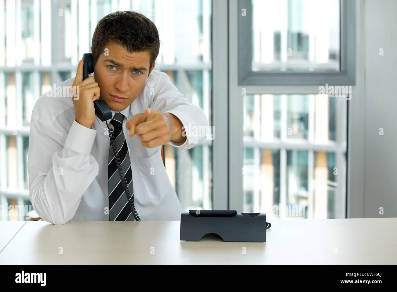 portrait of young confident caucasian businessman talking on phone Stock Photo