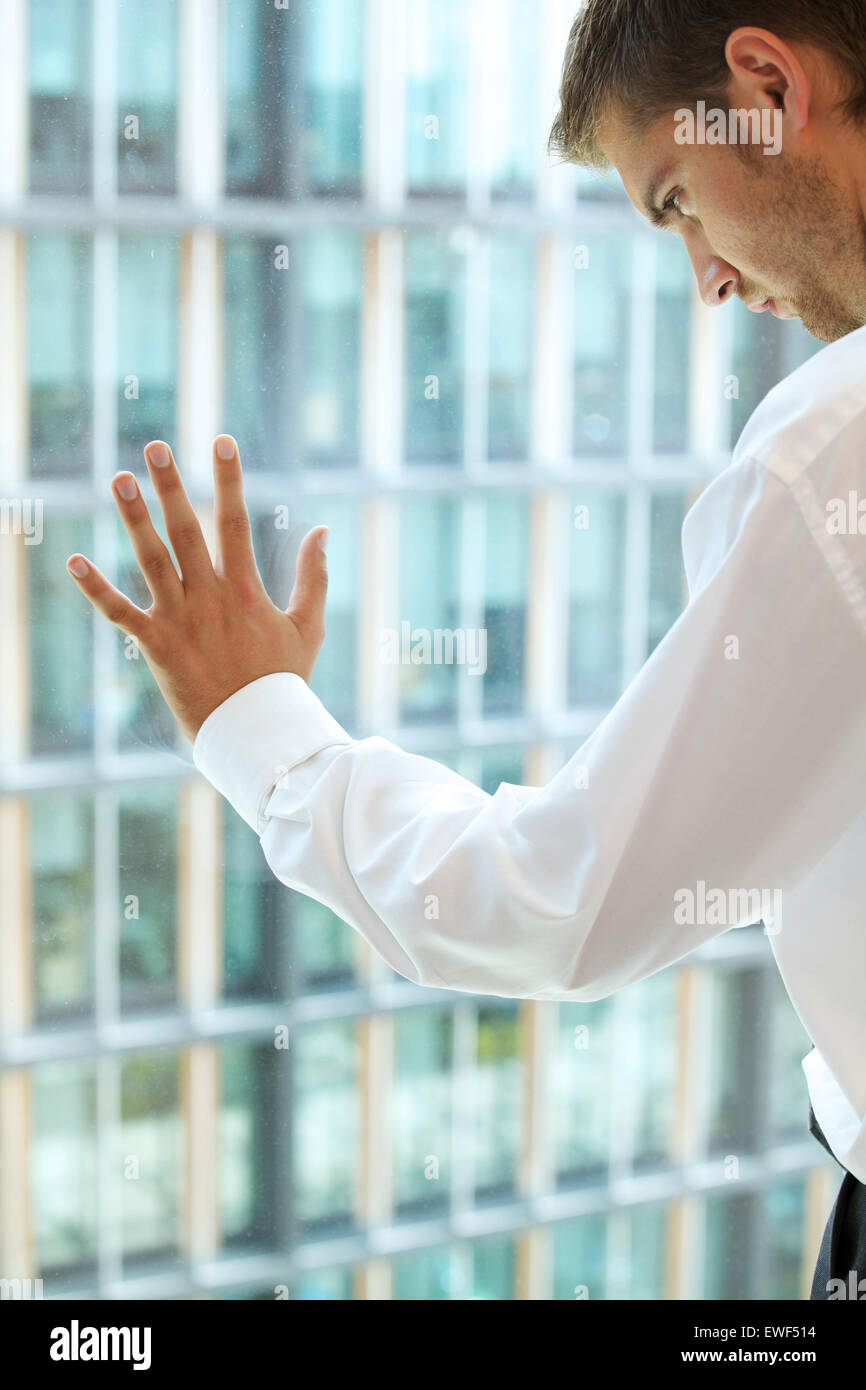 Young caucassian businessman standing against office window Stock Photo