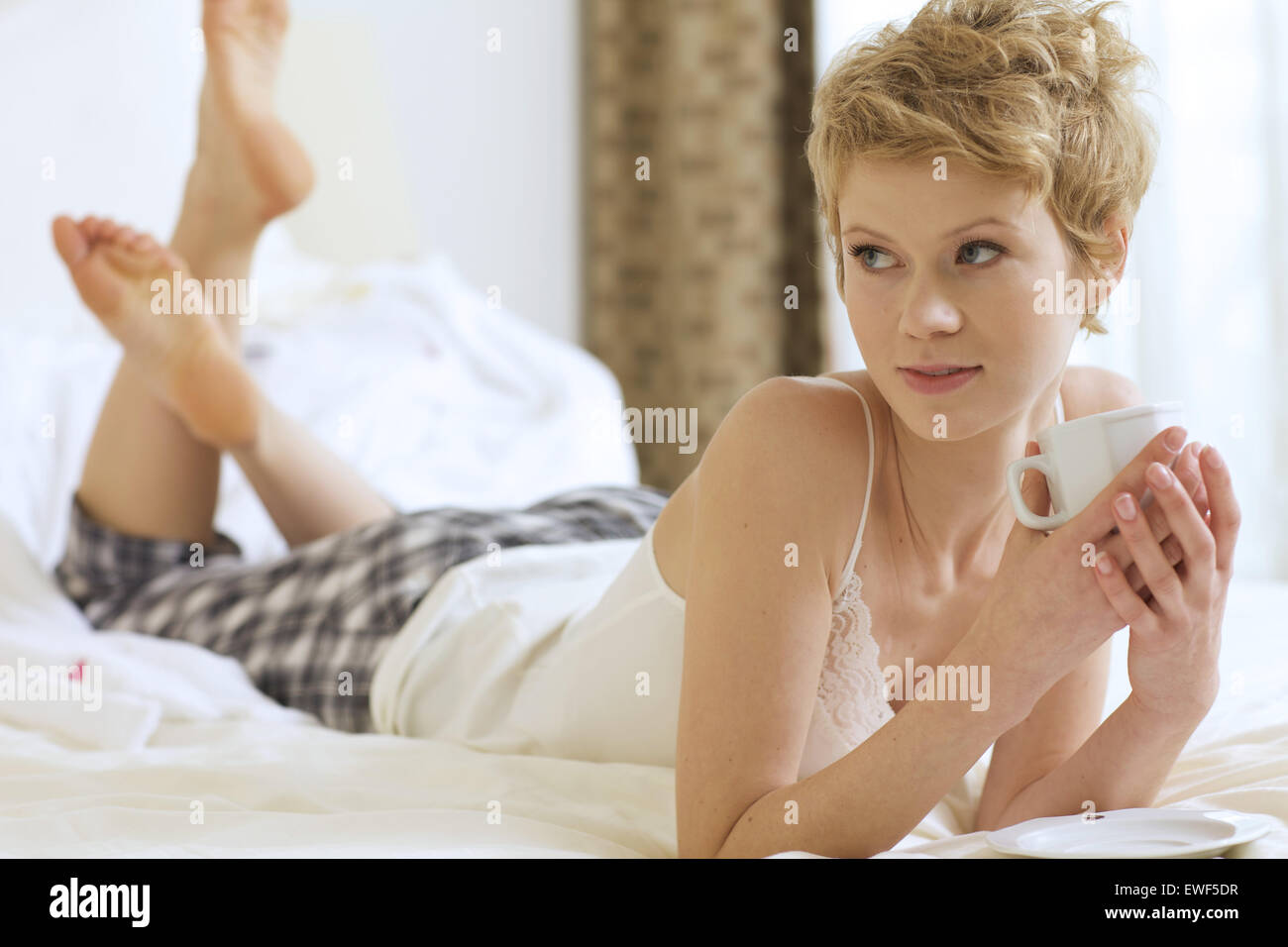 Woman drinking coffee in bed Stock Photo