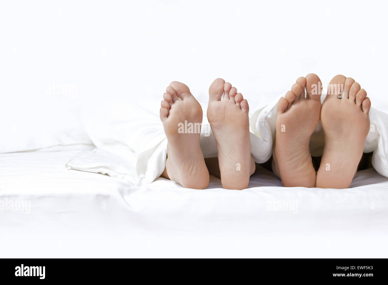 Couple's feet on the bed Stock Photo