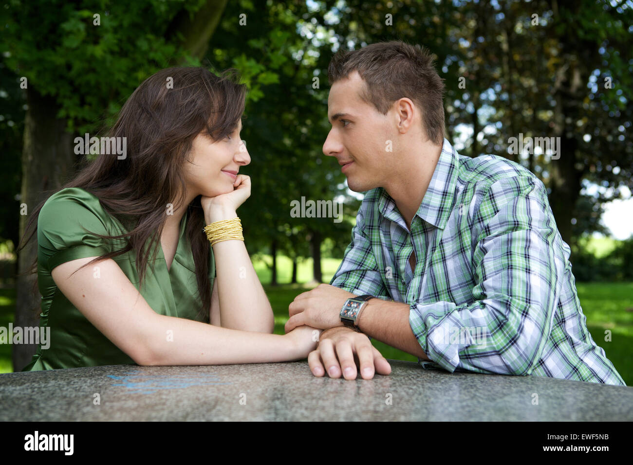 Young couple holding hands and looking at each other Stock Photo - Alamy
