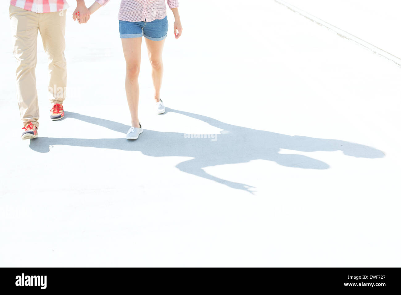 Low section of couple walking on street Stock Photo