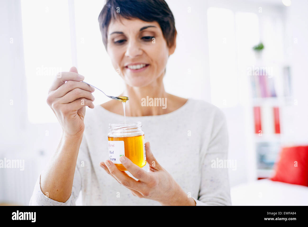 WOMAN EATING HONEY Stock Photo