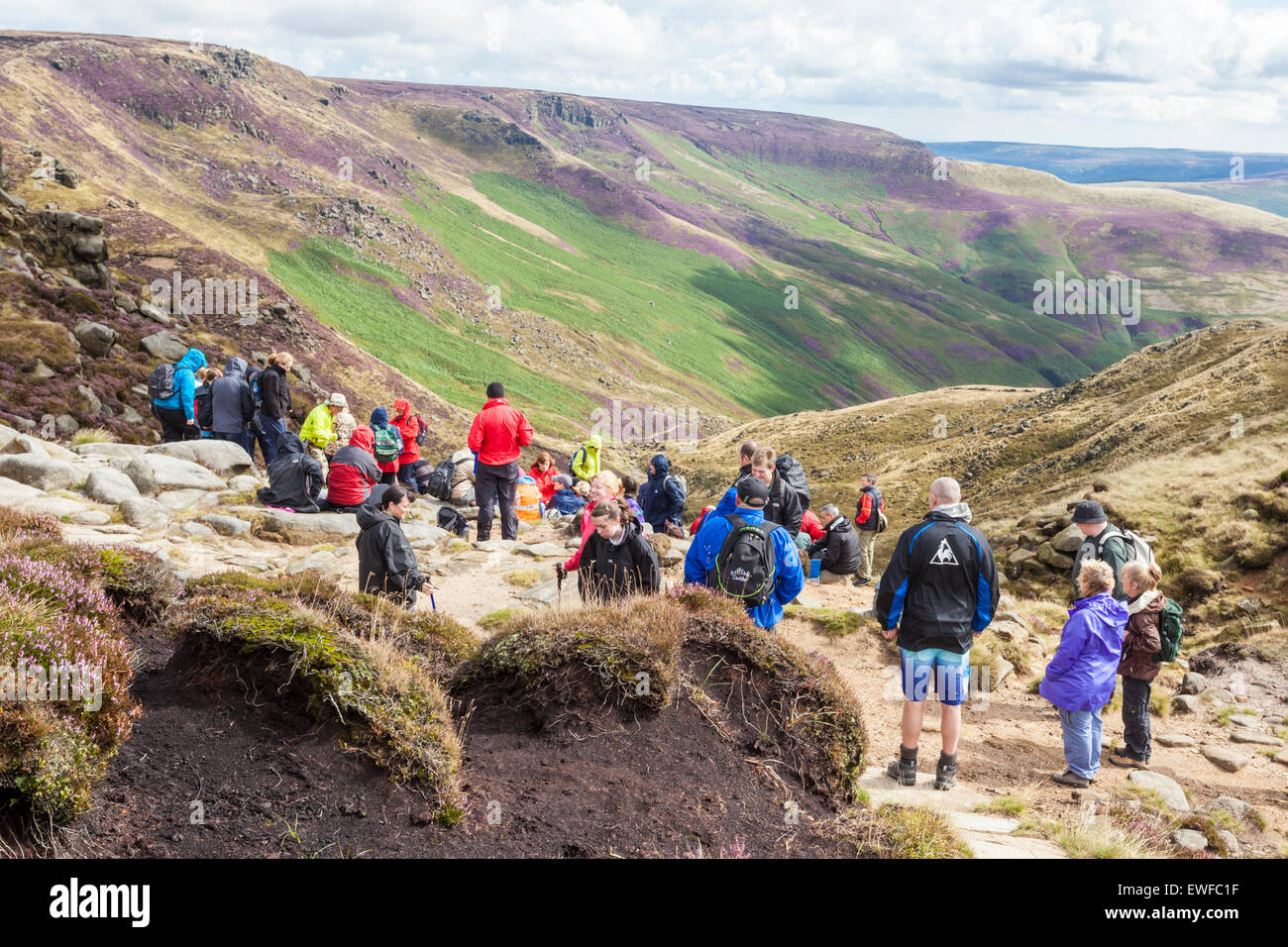 Hikers or walkers resting and viewing the countryside after walking up Grindsbrook Clough, Kinder Scout, Derbyshire, Peak District, UK Stock Photo