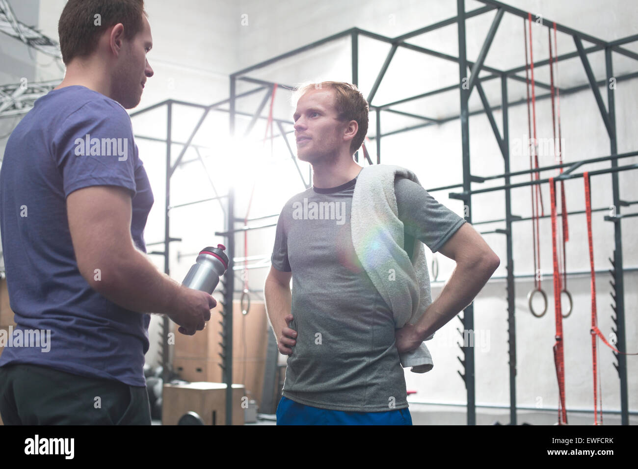 Male friends talking in crossfit gym Stock Photo