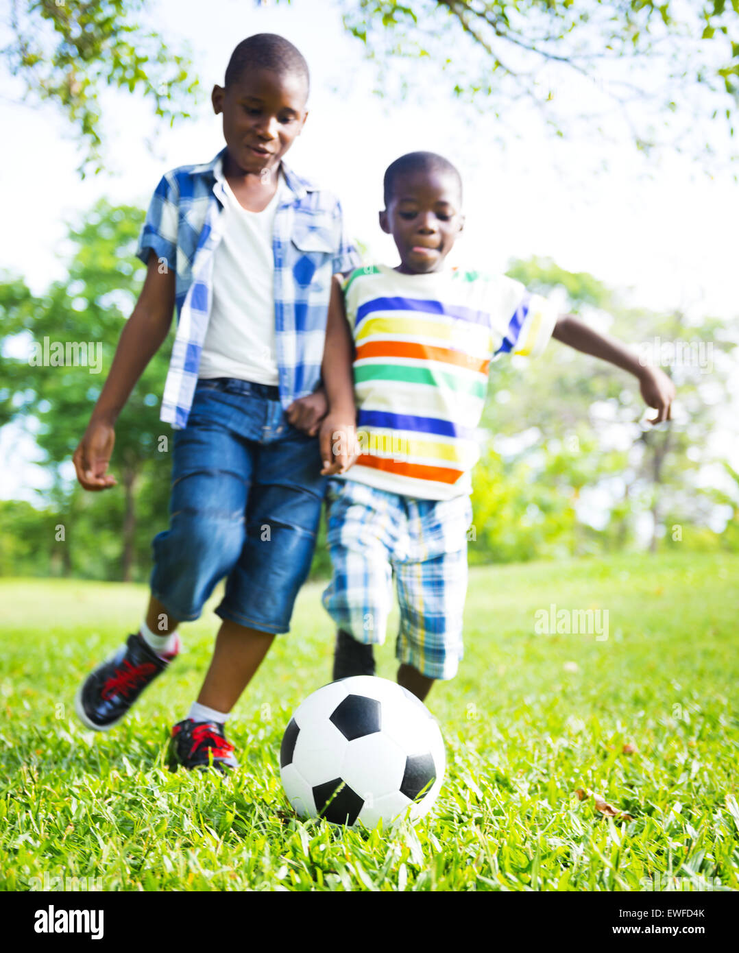 Chldren playing football Focus on the ball. Stock Photo