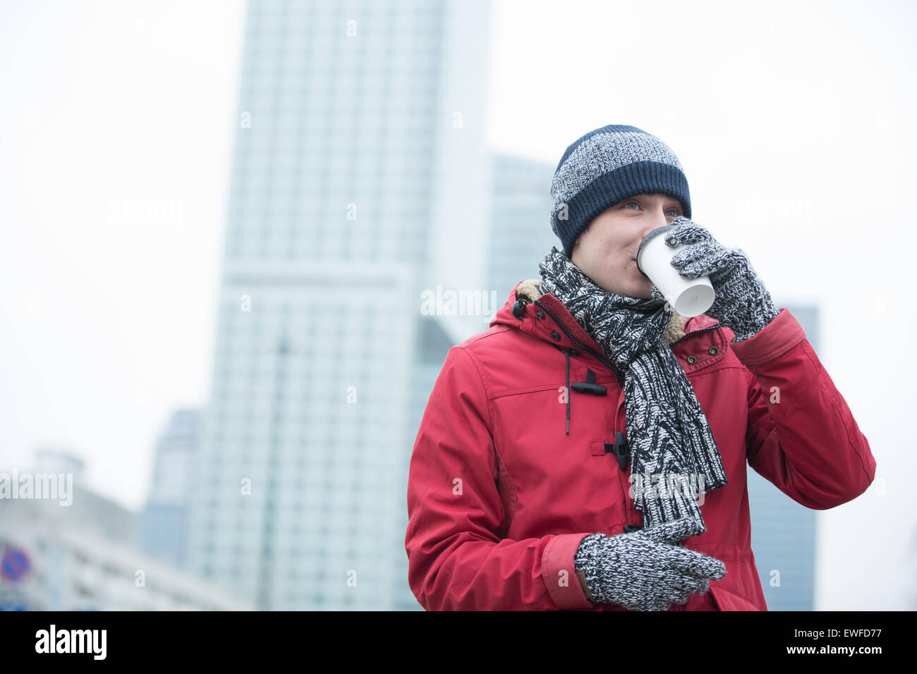 Man in warm clothing drinking coffee outdoors Stock Photo