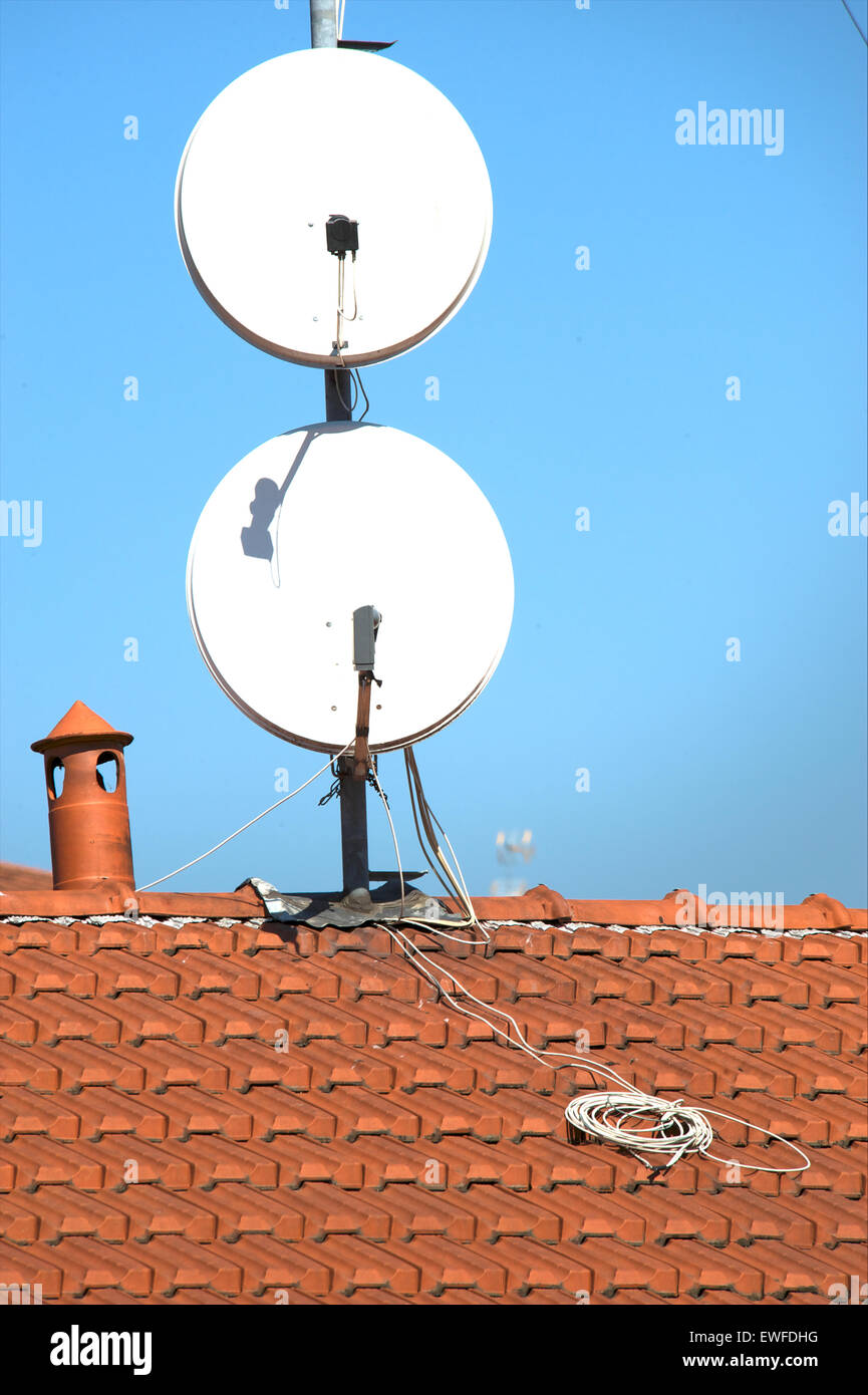 Satellite dishes on a tiled roof Stock Photo Alamy