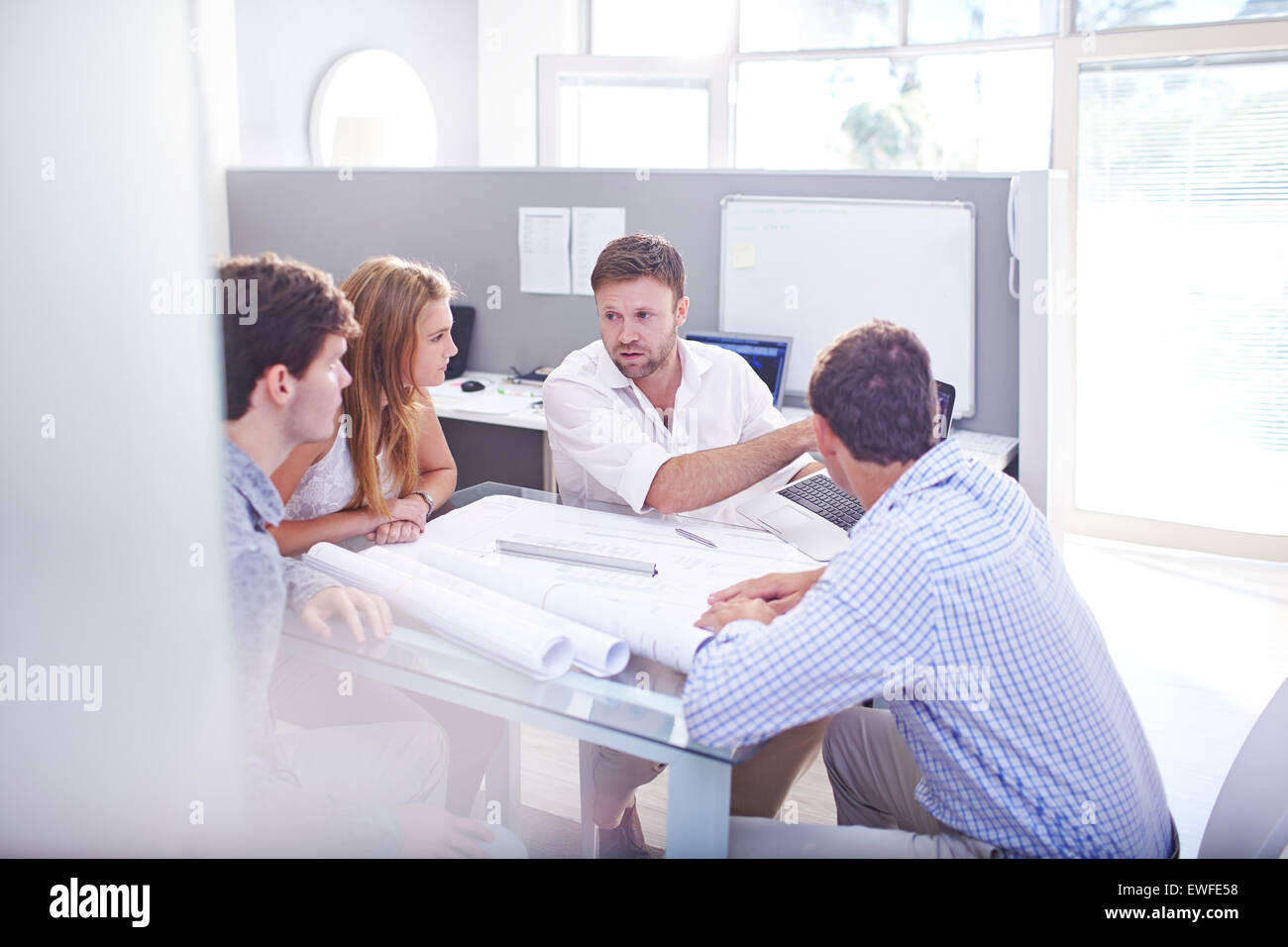 Architects discussing blueprints in meeting in office Stock Photo