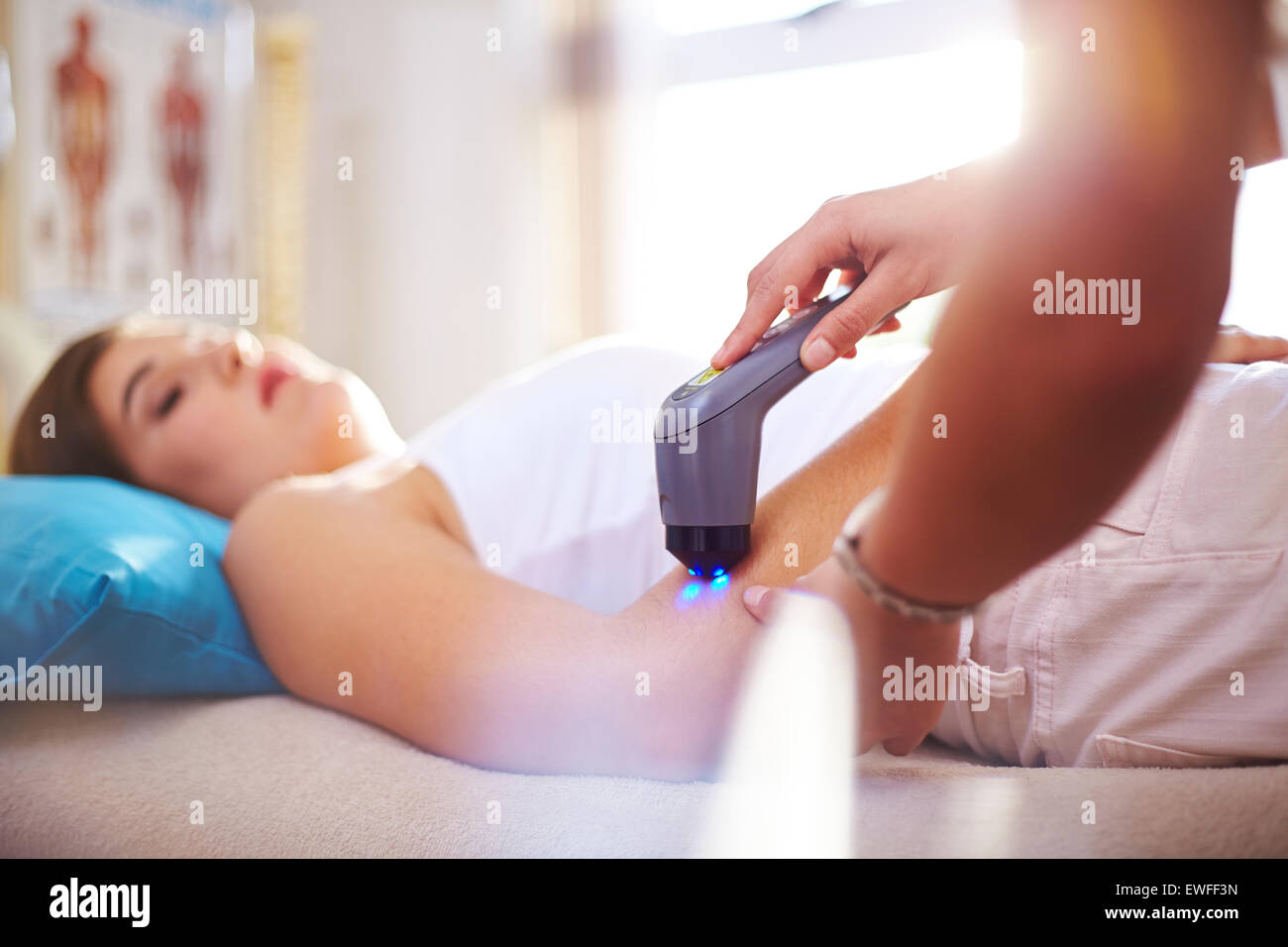 Physical therapist using ultrasound probe on woman’s arm Stock Photo