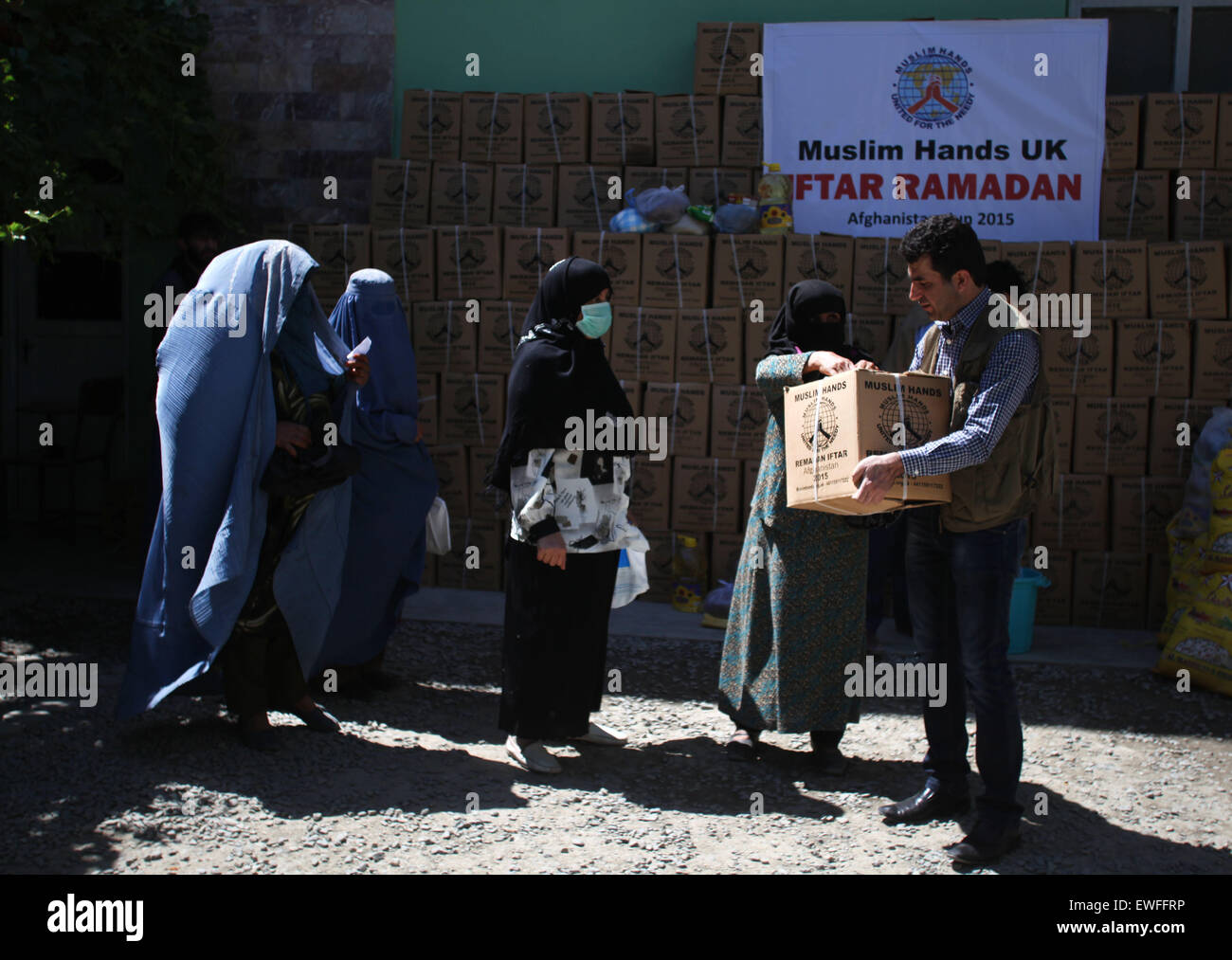 (150625) -- KABUL, June 25, 2015 (Xinhua) -- Afghan women receive food donated by Muslim Hands International organization for poor people during the holy month of Ramadan in Kabul, Afghanistan, June 25, 2015. (Xinhua/Ahmad Massoud) Stock Photo
