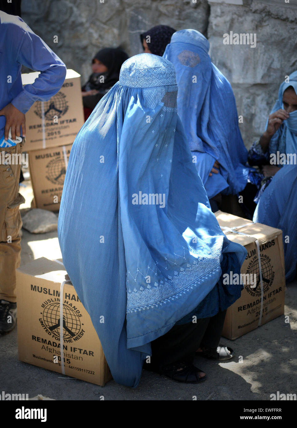(150625) -- KABUL, June 25, 2015 (Xinhua) -- Afghan women wait for transportation after receving food donated by Muslim Hands International organization for poor people during the holy month of Ramadan in Kabul, Afghanistan, June 25, 2015. (Xinhua/Ahmad Massoud) Stock Photo