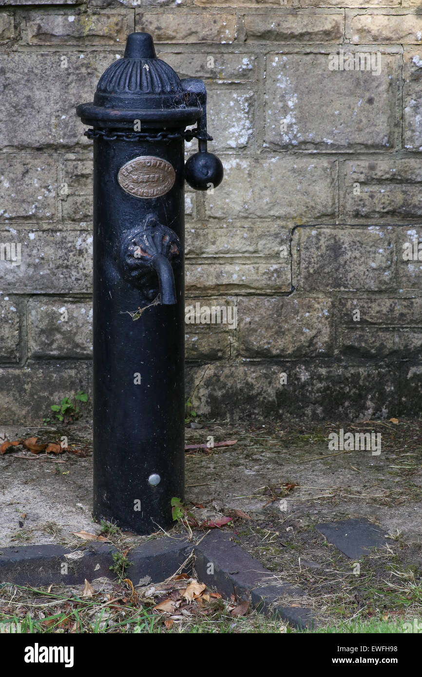 Antique with chain blocked drinking fountain and water pump Stock Photo