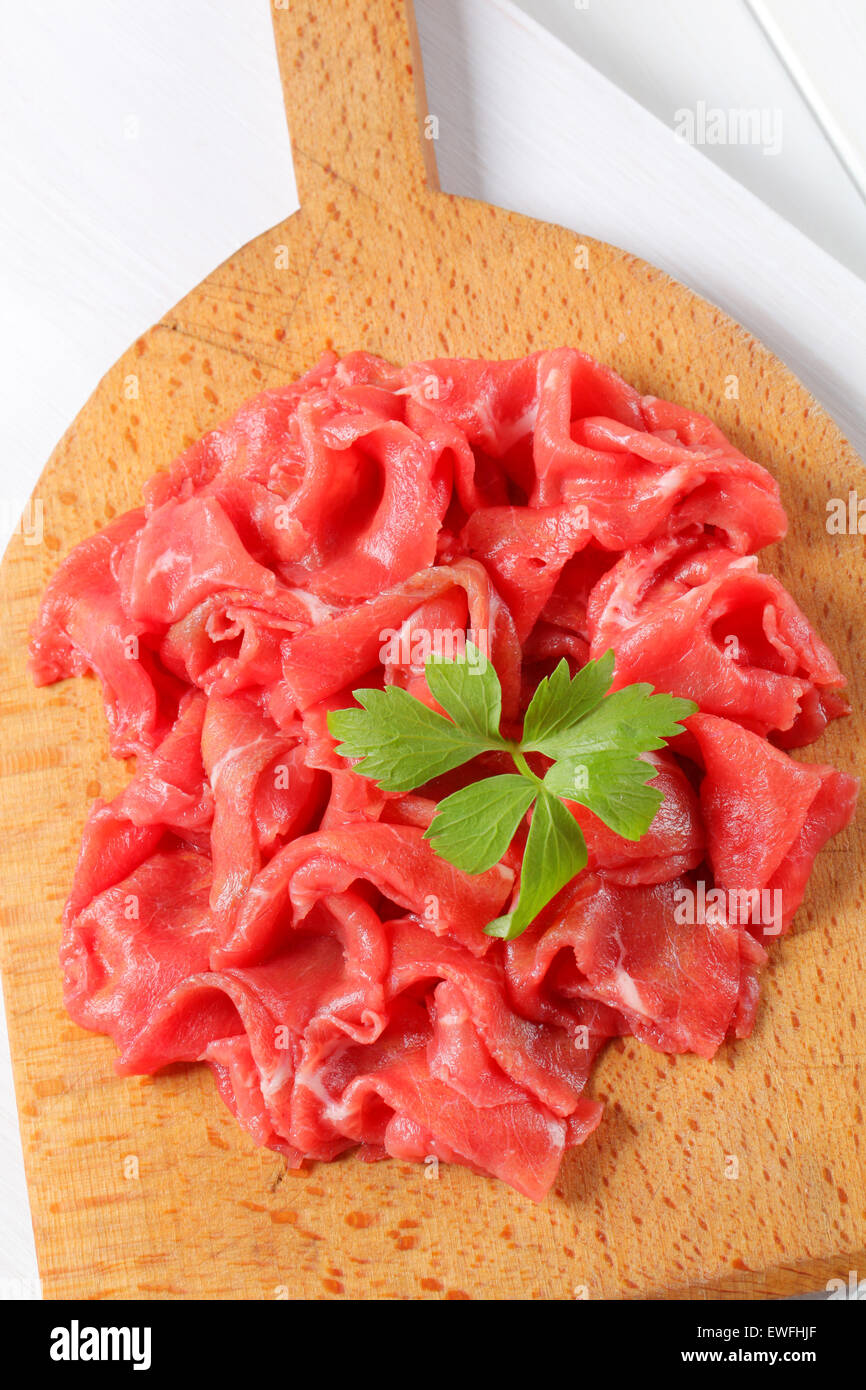 Uncuttable Meat Thinly sliced raw beef meat on cutting board Stock Photo - Alamy