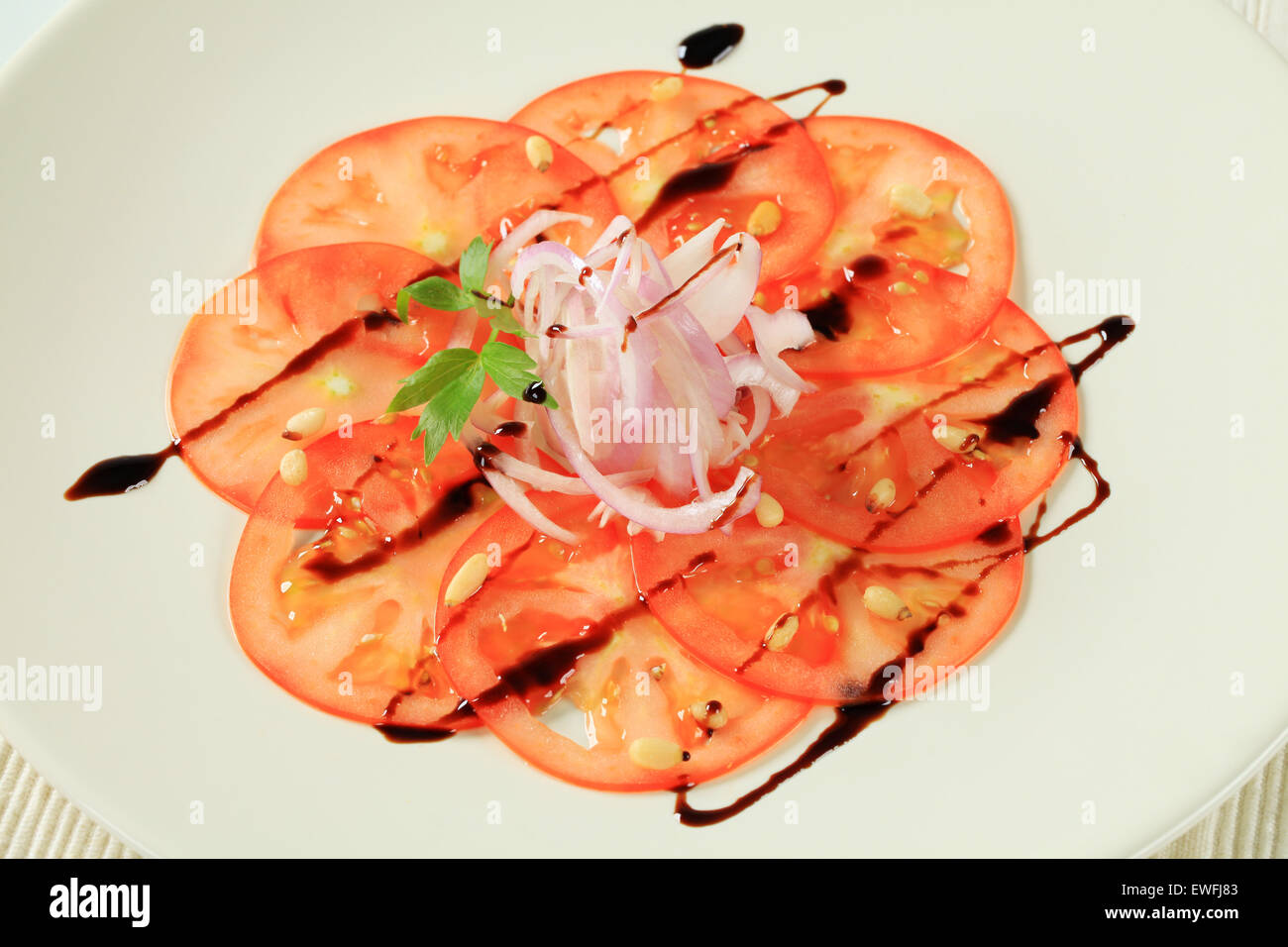 Tomato carpaccio with onion and balsamic vinegar Stock Photo