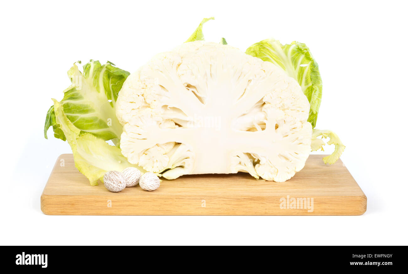 Cauliflower and nutmeg on a wooden chopping board against white background Stock Photo