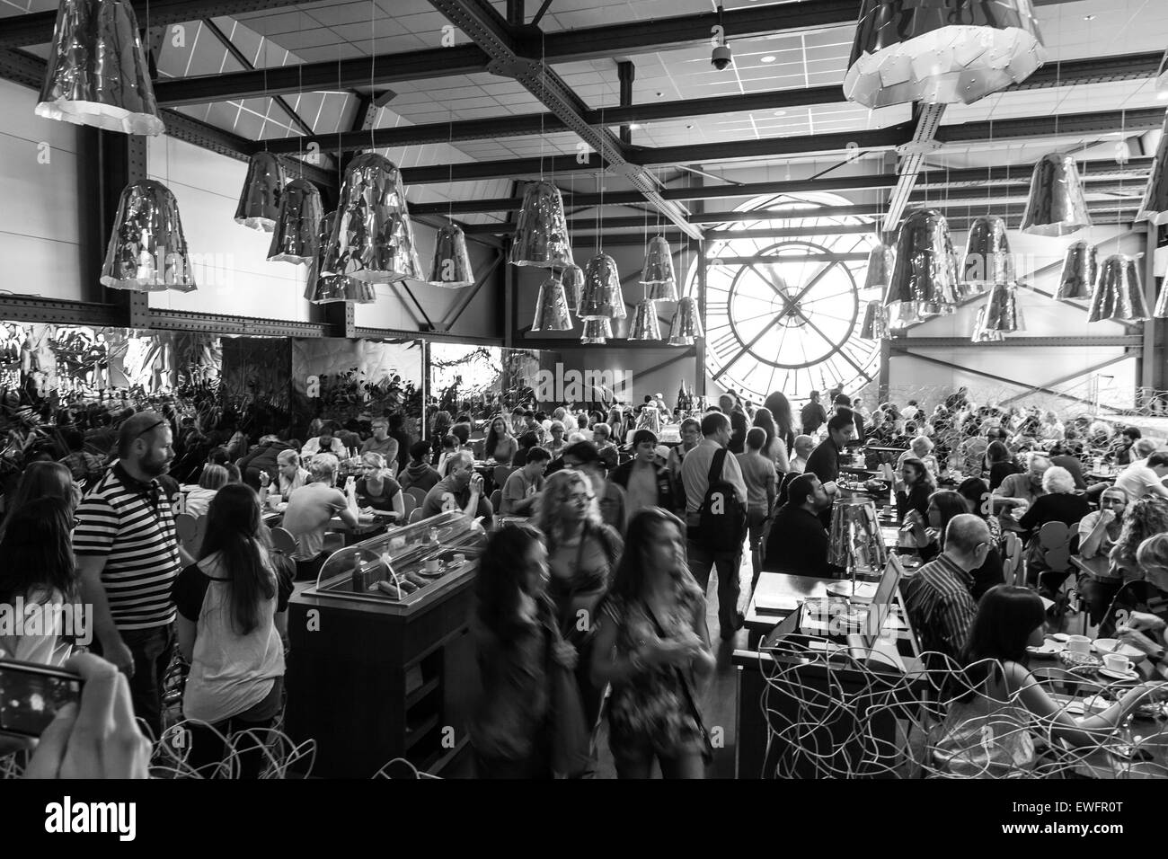 Paris, France - August 10, 2014: Restaurant with ancient clock window in Orsay Museum is full with visitors and personnel, black Stock Photo