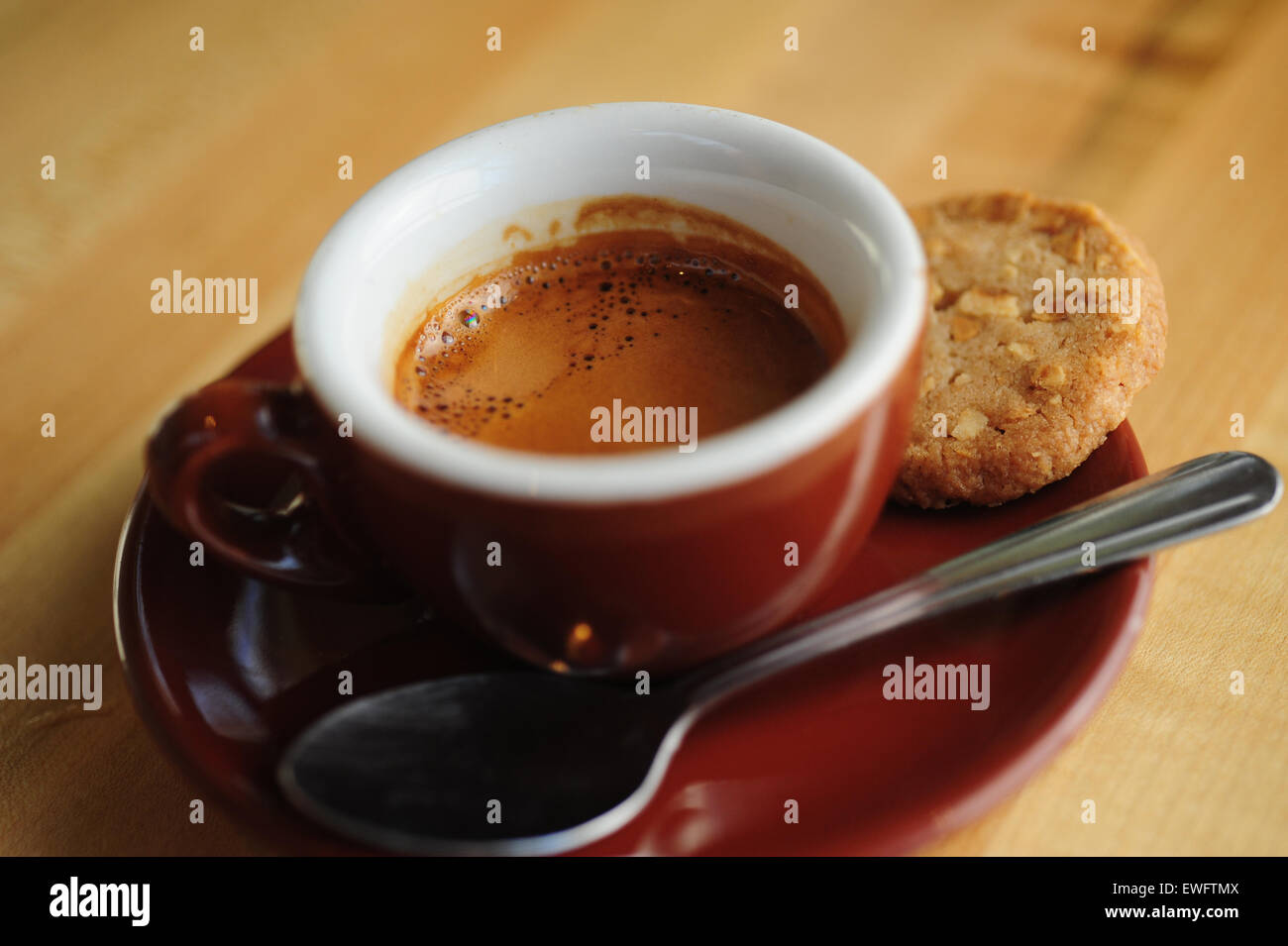 Food Coffee Cafe Espresso beverage served in a demitasse ceramic cup with cookie on the side Stock Photo