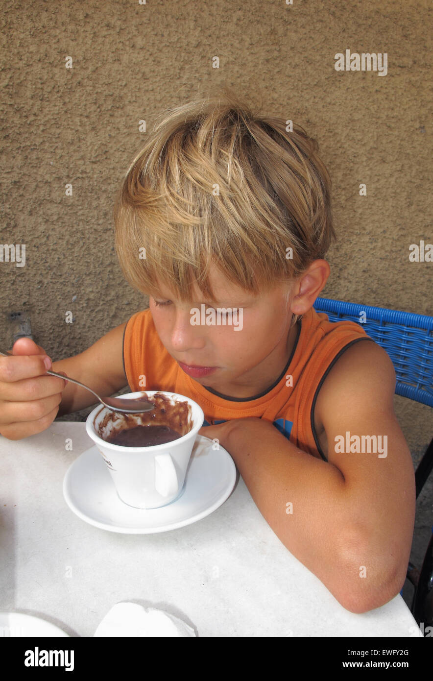 Berlin, Germany, boy spooned listless in a cup of cocoa Stock Photo