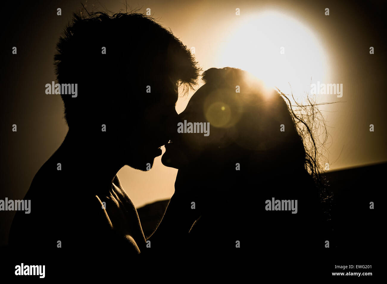 a couple kissing against a moonlit sky black and white Stock Photo
