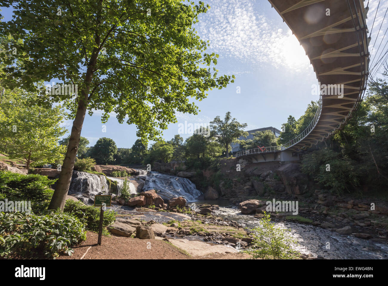 The Liberty bridge, a curved suspension bridge, crosses the Reedy River falls in beautiful and exciting downtown Greenville, SC. Stock Photo