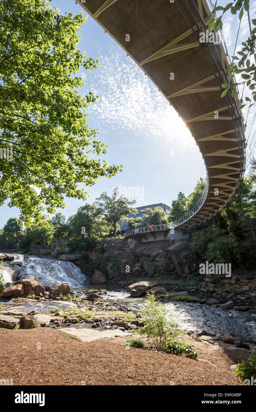 The Liberty bridge, a curved suspension bridge, crosses the Reedy River falls in beautiful and exciting downtown Greenville, SC. Stock Photo