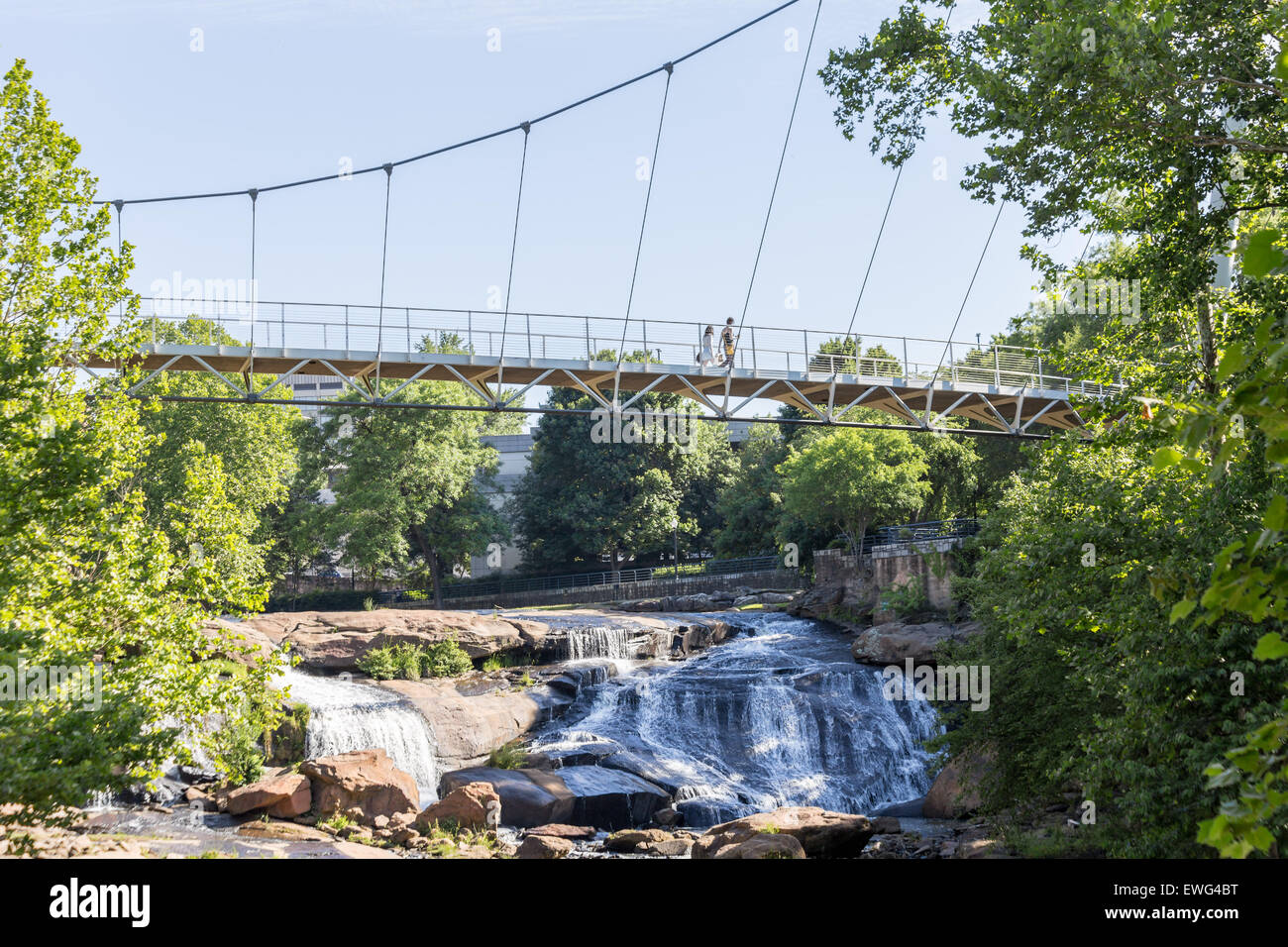 The Liberty bridge, a curved suspension bridge, crosses the Reedy River falls in beautiful and exciting downtown Greenville, SC. Stock Photo