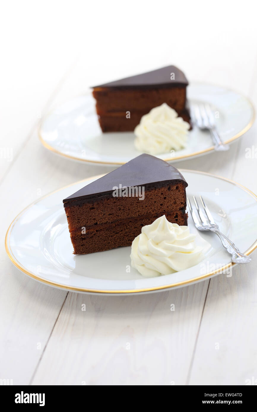 homemade sachertorte, Austrian chocolate cake isolated on white wooden background Stock Photo