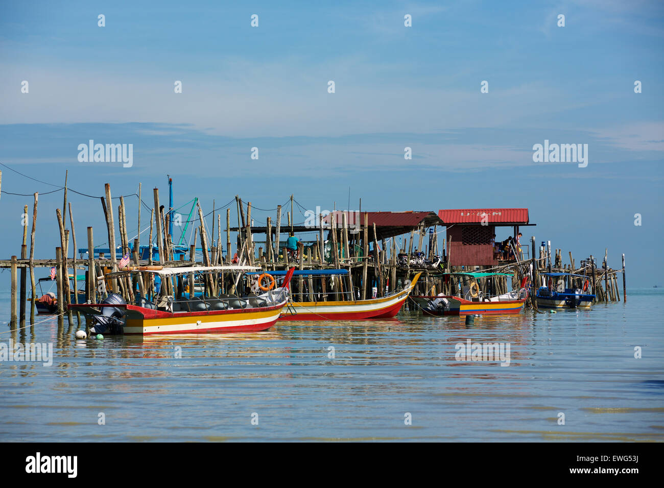 Collection of assorted boats tied up alongside a rickety jetty at Teluk Bahang on Penang Island Malaysia Stock Photo