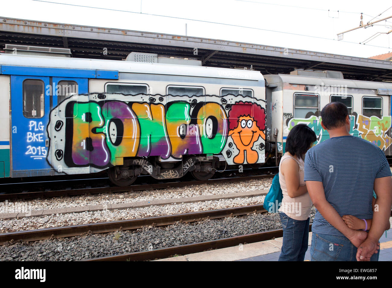 Graffiti train station couple waiting for train trainstation Lucca Tuscany Italy Stock Photo