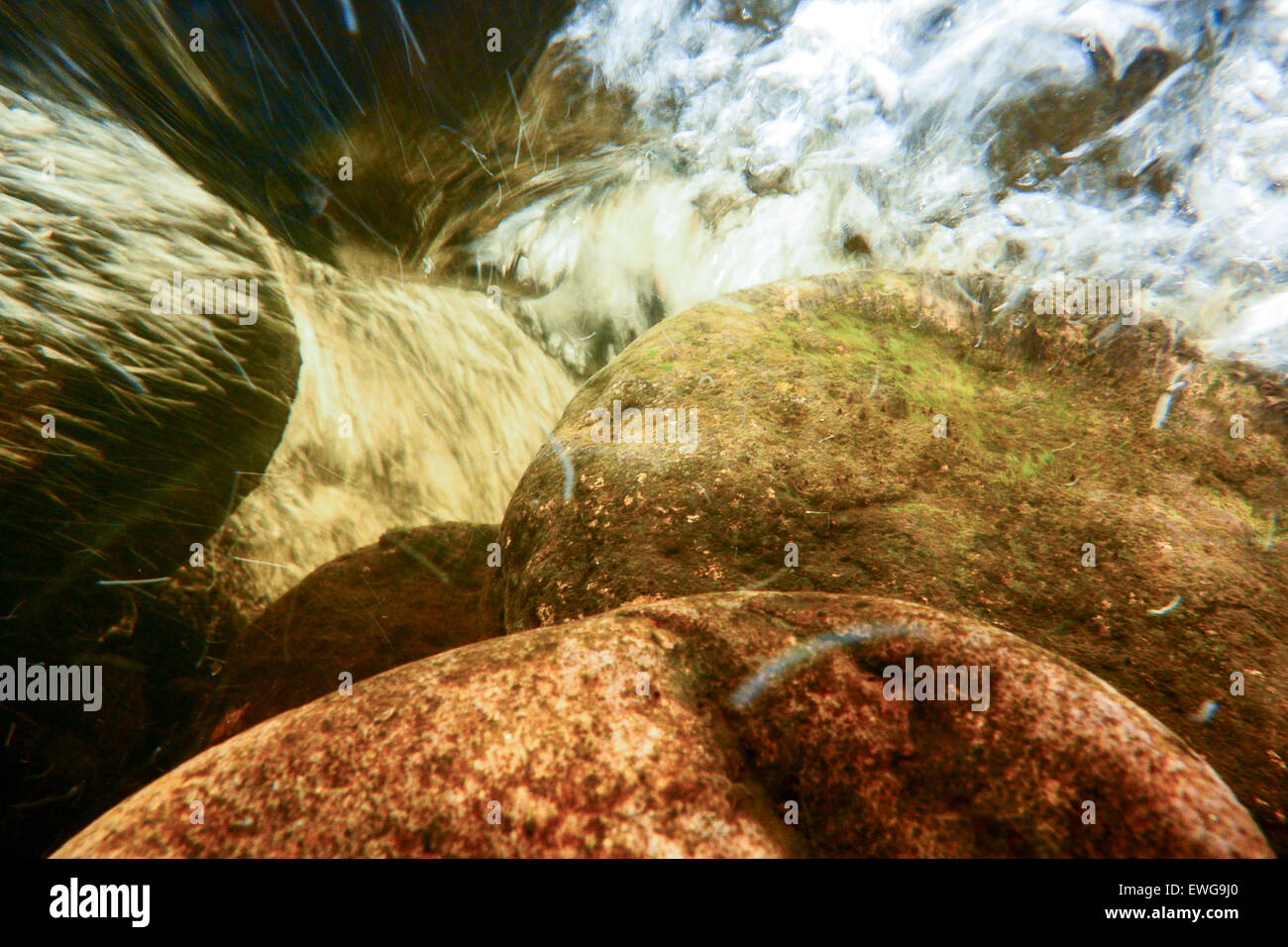 Under surface of a fast flowing river, full of air bubbles, oxygenating the water. Cumbria, UK Stock Photo