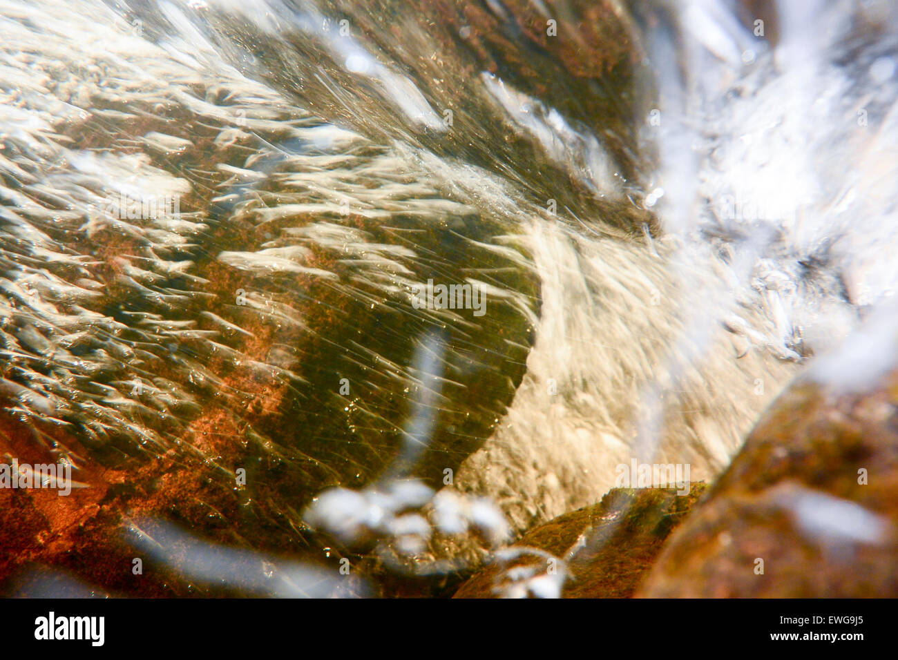Under surface of a fast flowing river, full of air bubbles, oxygenating the water. Cumbria, UK Stock Photo