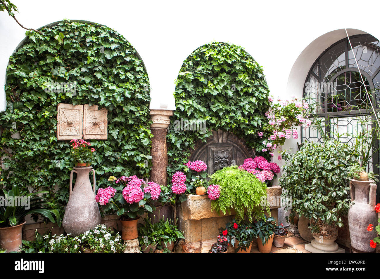 Spanish courtyard with arches architecture,  fountain, vases and flowers Stock Photo