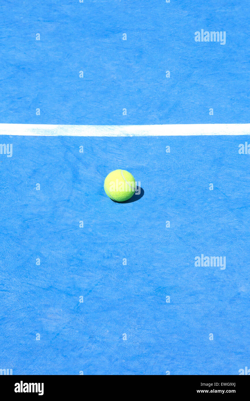 Blue tennis court with  one yellow ball on the floor Stock Photo