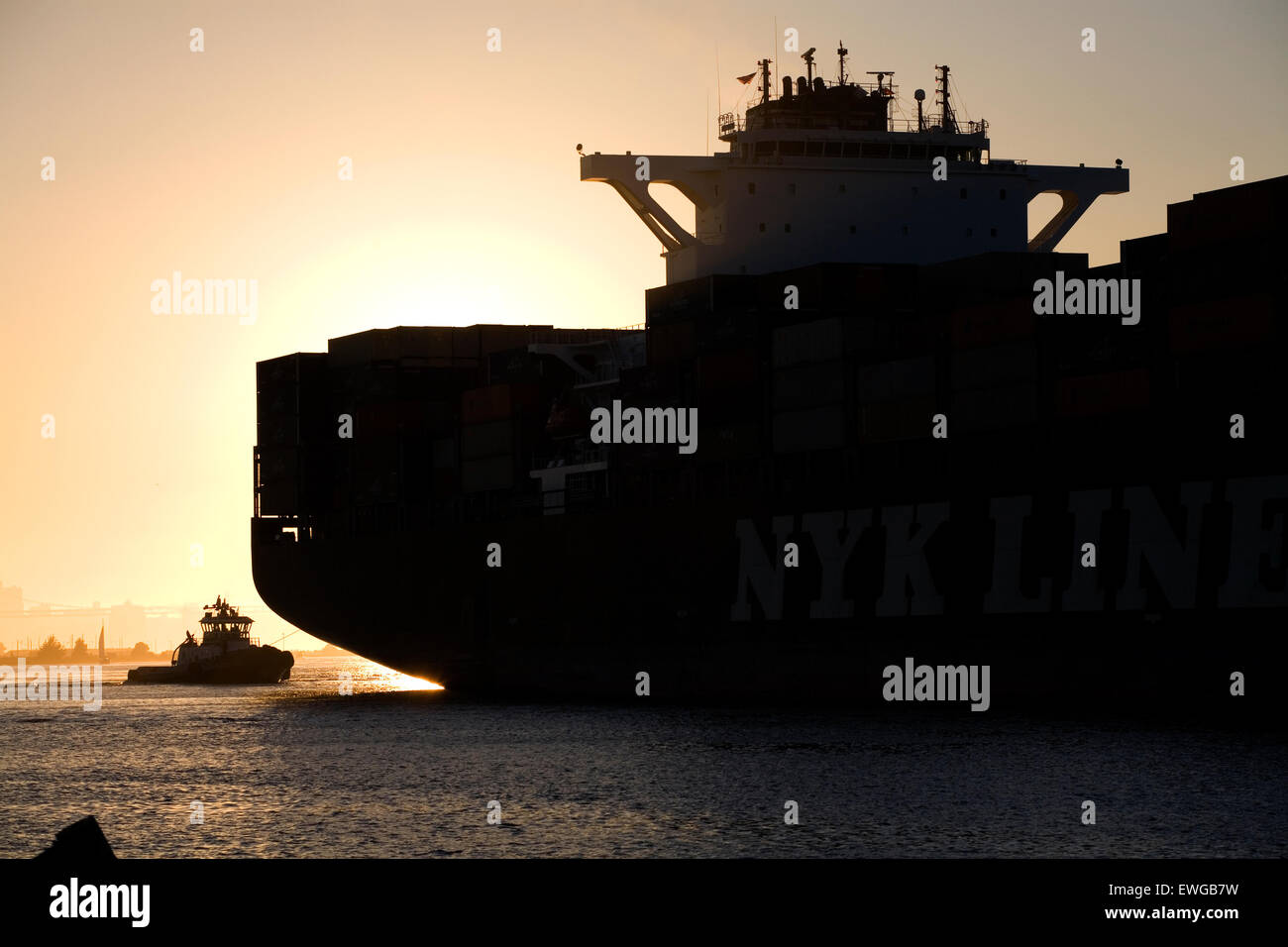 containership and tug at sunset Stock Photo