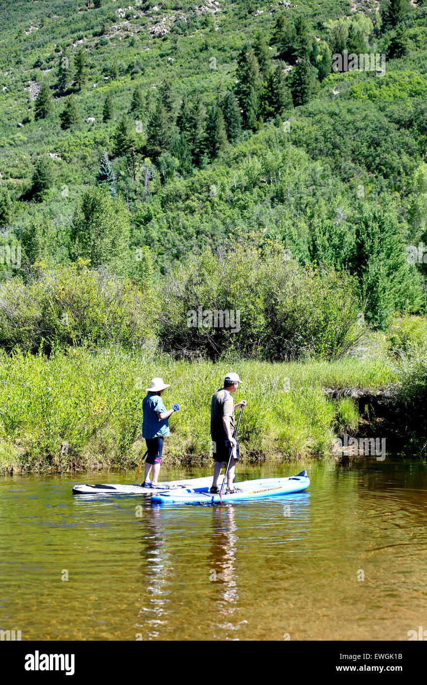 Stand up paddle boarding couple, Roaring Fork River, near Aspen