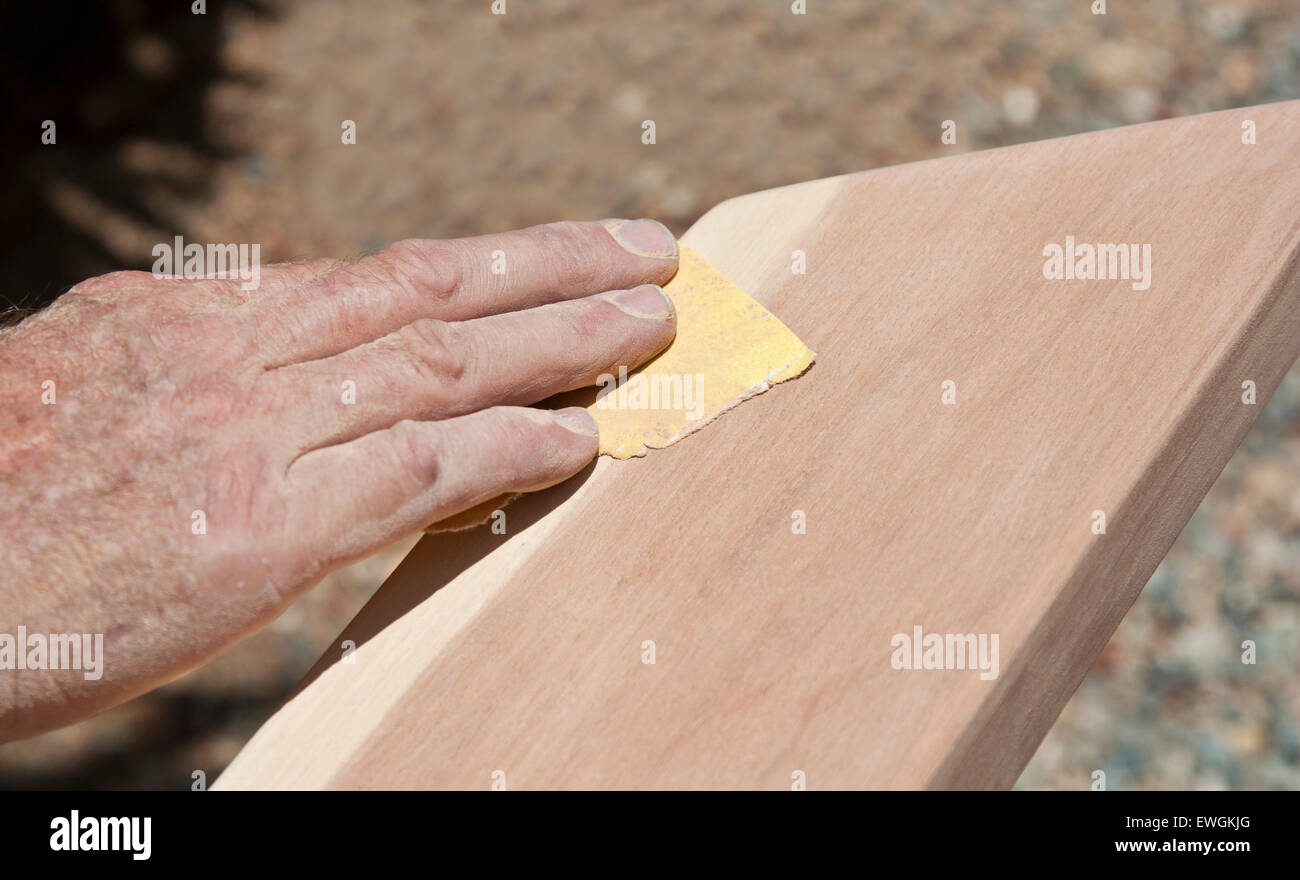 male hand sanding a piece of timber by hand Stock Photo Alamy